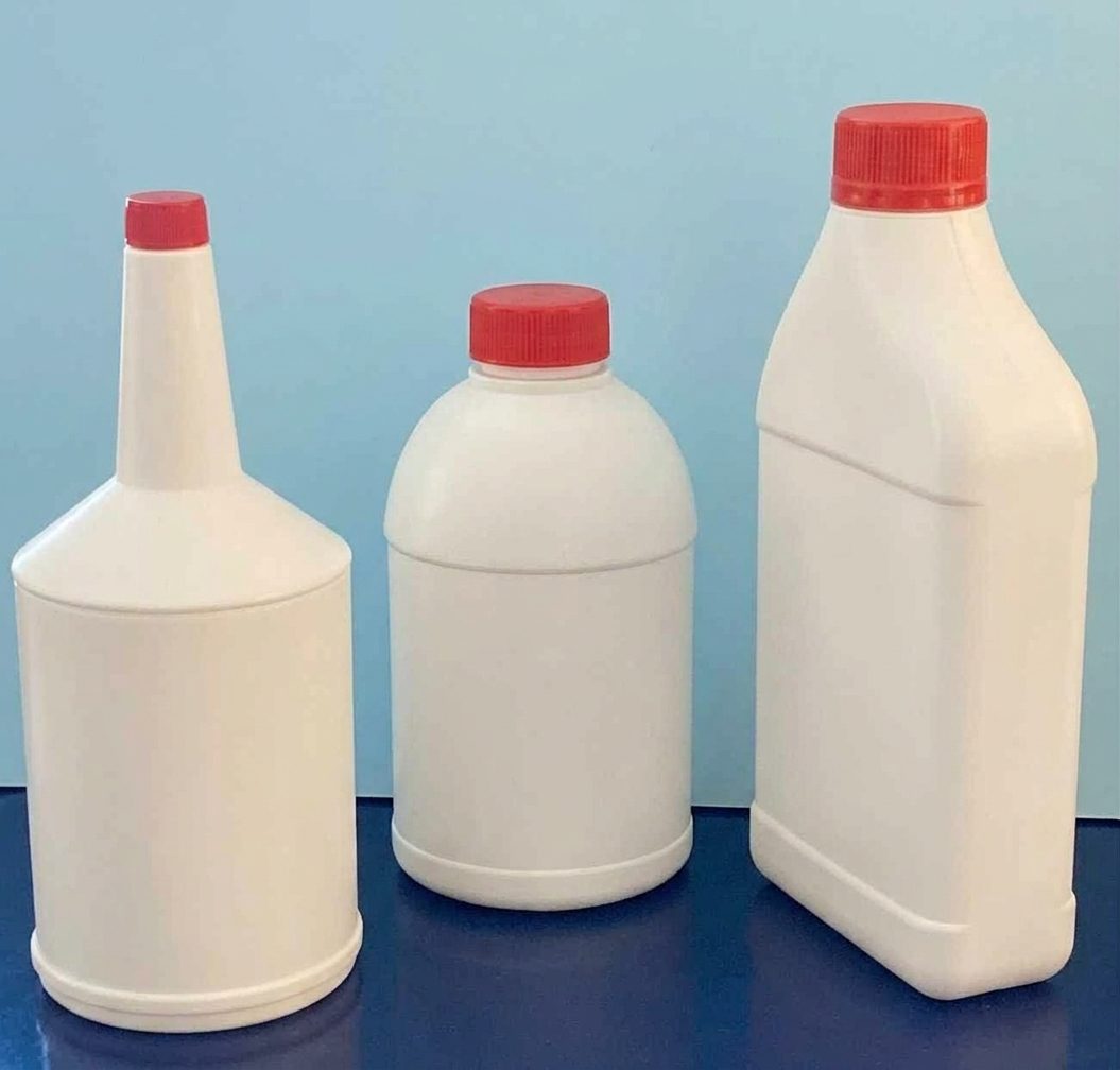 Tres botellas plásticas con tapa roja, una de ellas con pico dosificador