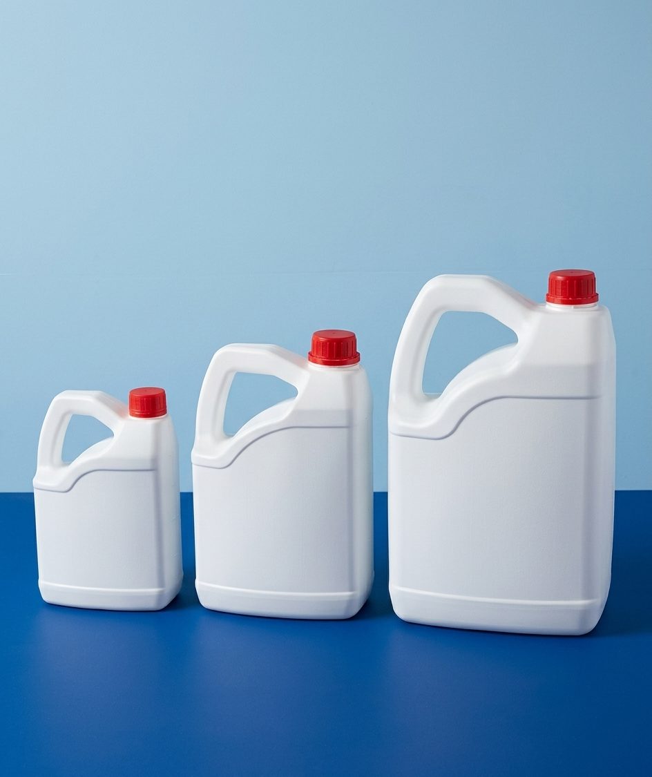 Tres garrafas plásticas blancas de distintas capacidades con tapa roja
